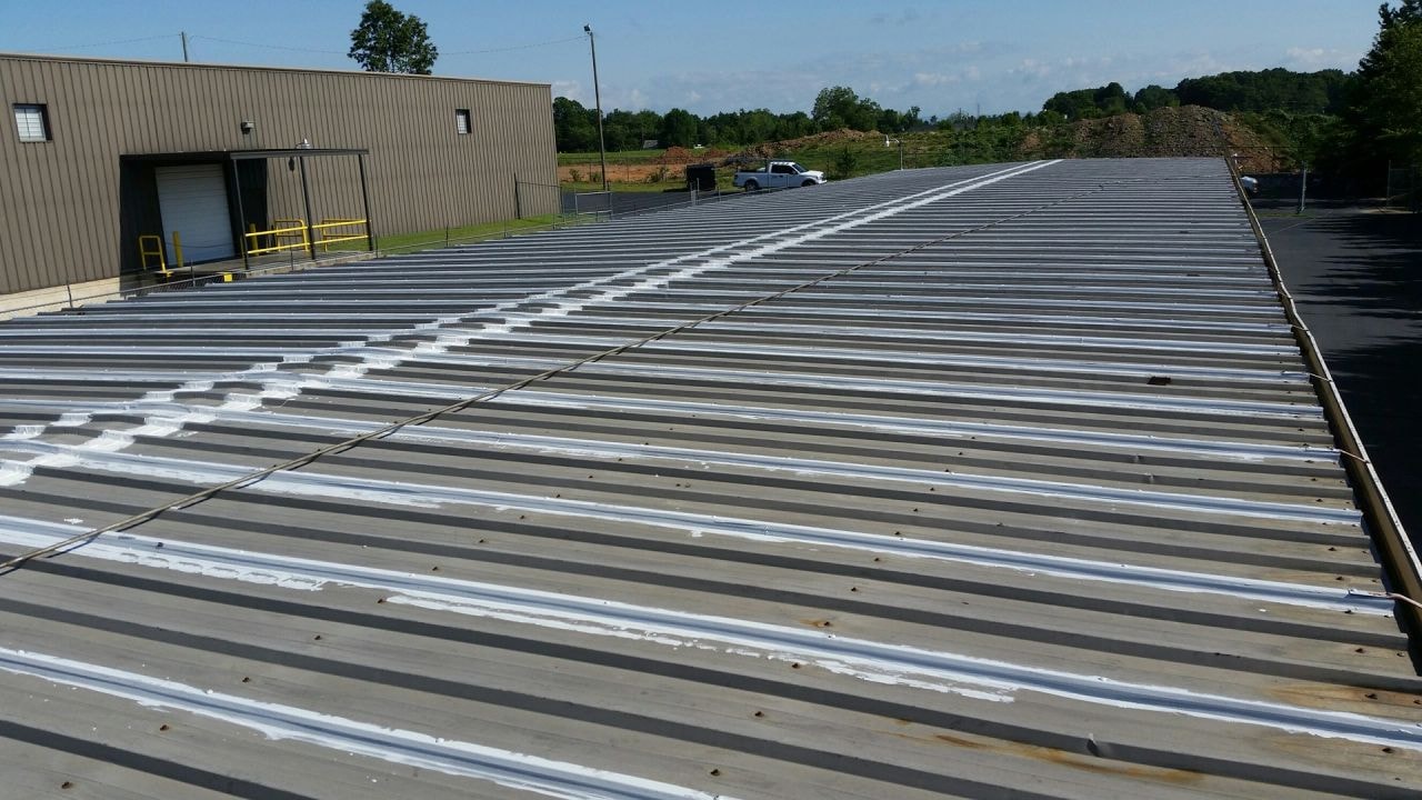 Roof coating in progress — aluminum coating being applied